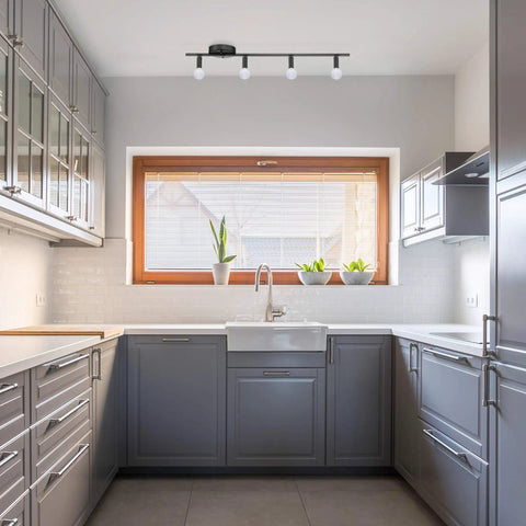 Modern kitchen interior with Monroe 4 Light Slim Profile Track Lighting Matte Black Finish With Adjustable Heads installed above window.