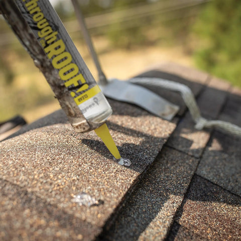 Applying Through The Roof Sealant 10.5 Oz Cartridge Clear That Stays Crystal Clear With Elastic Flex onto shingle roof patch