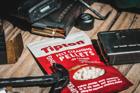 Felt Cleaning Pellets for 22 Caliber With Jag, product packaging on wooden surface with ammunition and tools.