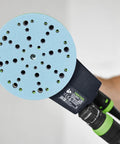 Man holding orbital sander with attached Granat 100 Grit 6 Inch Sanding Disc, designed for repairing paints, fillers, and coatings.