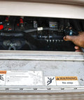 Heavy Duty Battery Booster Cables 16 Feet With 500 Amp Clamps being used on a vehicle's battery by someone in a blue sleeve.