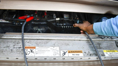Person using Beefy 20 Foot Heavy Duty Jumper Cables With Four Gauge Copper Welding Cable And 500 Amp Clamps Black And Red Booster Cables