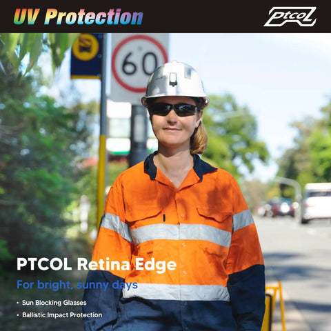 Construction worker wearing safety helmet and tinted glasses with UV protection outdoors, urban background visible.