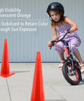 High Visibility Orange Safety Cone For Traffic And Worksites, 28 Inch Durable LDPE Cone in a play area with a girl biking nearby