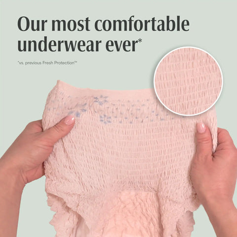 Hands showing textured material of Fresh Protection Adult Incontinence Underwear For Women Large 28 Count Disposable Maximum Absorbency Blush.