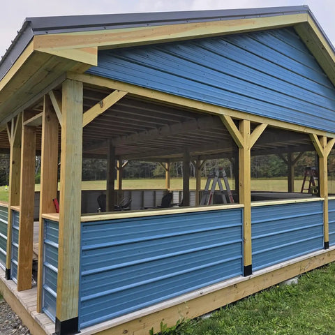 A blue carport supported by 6x6 wood posts with 4 Pack Bolt Down Square Fence Post Brackets for stability and durability.