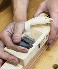 Hand using Pro Grade Japanese Kanna Pull Plane Hitachi Aogami Blue Steel Number Two Blade Solid Oak Body 58mm for woodworking.