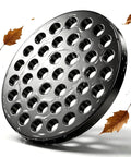 Solid 4.5 Inch Cast Iron Floor Drain Cover Round Heavy Duty Drain Strainer For Bathrooms And Patios Bombproof Grime Guard shown with water and leaves.