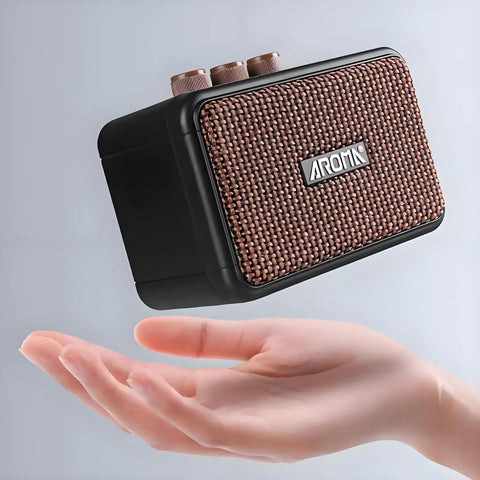 Aroma Mini 5W Guitar Amp With Clean And Overdrive Channels, Rechargeable Portable Electric Guitar Amp AG 04 held above hand