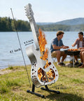 Guitar-shaped stainless steel wood burning fire pit with stand by a lake, efficient burn design, perfect for cozy evenings.