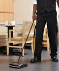 Dual-Action Mechanical Sweeper Cordless Low-Profile For Hard Floors And Carpet With Durable Steel And Bristle Rolls in use.