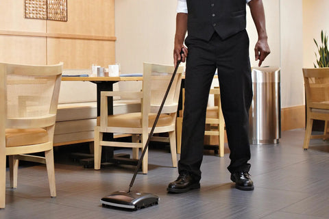 Dual-Action Mechanical Sweeper Cordless Low-Profile For Hard Floors And Carpet With Durable Steel And Bristle Rolls in use.