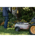 Tow-Behind Garden Sprayer With 15 Gallon Tank, 30 Inch Boom in use on lawn, spraying with 23 Inch Wand, near garden tractor
