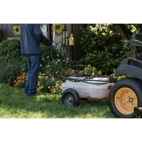 Tow-Behind Garden Sprayer With 15 Gallon Tank, 30 Inch Boom in use on lawn, spraying with 23 Inch Wand, near garden tractor
