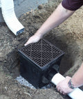 Square Catch Basin Drain Kit 12-Inch For Lawns And Landscaping With Two-Opening Catch Basin Drain Stormwater Solution Easy Install Includes Two Adapters One Outlet Plug And Plastic Drain Grate Black installed in ground.