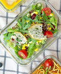 Glass container filled with fresh salad, part of Eight Pack 30 Oz Glass Meal Prep Containers With Airtight Lids Glass Food Storage.