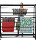 User organizing rolls of fabric on a Heavy Duty Commercial Fabric Roll Storage Rack With Adjustable Spacing Rock Solid For Indoor And Outdoor Use No Sweat Textile Organization Top Shelf Steel Unit.