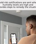 Person using smartphone app with 2 In 1 Smoke Detector And Indoor Air Quality Monitor With WiFi And Alexa Compatibility installed on ceiling.
