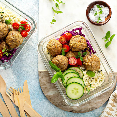 10 Pack 22 Oz Glass Meal Prep Containers With Airtight Locking Lids For Portion Control, Microwave Oven Freezer And Dishwasher Safe, BPA Free, Stackable Lunch Storage For Work, At The Gym, On The Go Leftovers Grey, filled with meatballs, cherry tomatoes, cucumber slices, rice, and fresh herbs