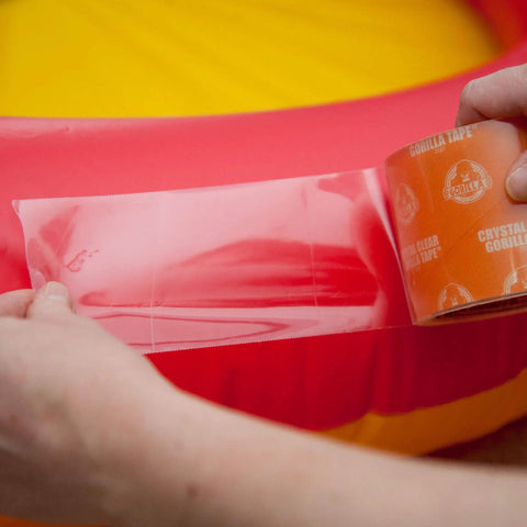 Applying Crystal Clear Heavy Duty Duct Tape For Indoor And Outdoor Repairs 2.83 Inch Wide By 15 Yard Roll on inflatable tube.