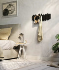 Sticks Wall Mounted Coat Rack With Five Retractable Pegs For Entryway Bedroom Or Office A Modern Space Saving Storage Organizer holding a bag and headphones on a bedroom wall.