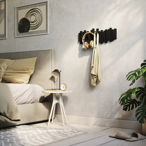 Sticks Wall Mounted Coat Rack With Five Retractable Pegs For Entryway Bedroom Or Office A Modern Space Saving Storage Organizer holding a bag and headphones on a bedroom wall.