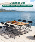 Outdoor use with 4 Pack Black Plastic Folding Chairs With Steel Frame For Outdoor Use No Fuss Portable Stackable Foldable Seating 350 Lb Capacity For Patio Garden Picnic Kitchen Events shown around a wooden table on a lakeside patio.