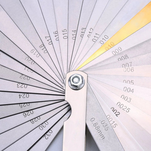 Front view of a 32-blade stainless steel feeler gauge with dual metric/imperial markings and central pivot.
