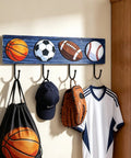 Hang Your Game Day Gear On This Slick Sturdy Four Hook Wooden Wall Rack Built For Displaying Baseball Basketball Football Jerseys And Athletic Room Storage with sports balls and gym gear.