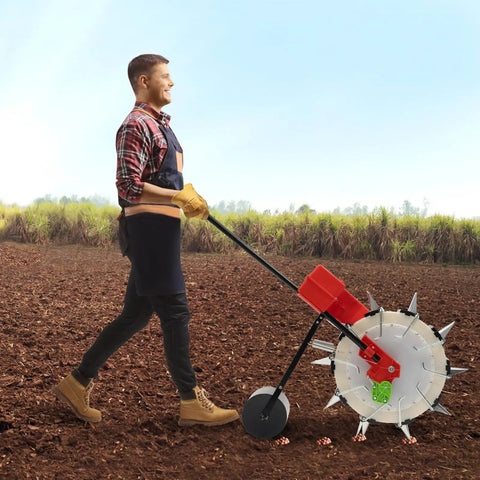 Person using manual hand push garden seeder walk behind row crop planter with 10 nozzles in a field.