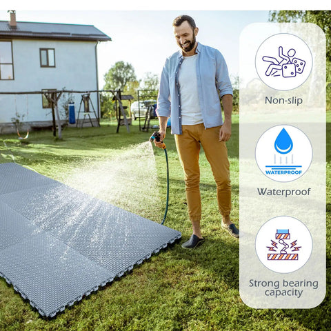 Man watering lawn with 50 Pack Interlocking Drainage Mats 10 By 10 Inch Rubber Floor Tiles for outdoor use shown in garden