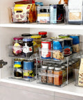 Two Tier Clear Organizer With Dividers For Kitchen Pantry Medicine Cabinet Bathroom Vanity And Under Sink Slide Out Storage Bin For Countertop Or Cabinet Multiuse See Through Organizer Keeps It Neat filled with various kitchen items.