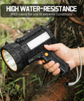 Hand holding Rechargeable Spotlight Flashlight With Solar Panels, 1000 Lumen Beast Outdoor Light in rain, highlighting water-resistance.
