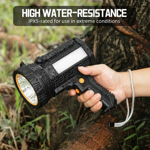 Hand holding Rechargeable Spotlight Flashlight With Solar Panels, 1000 Lumen Beast Outdoor Light in rain, highlighting water-resistance.