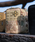 Rhino Rescue IFAK tactical first aid MOLLE pouch, front view; three pouches shown: camo center, tan left, black right.