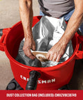 Man fitting dust collection bag into 16 Gallon 6.5 Peak HP Wet Dry Shop Vacuum With Built In Blower Port for garage cleanup