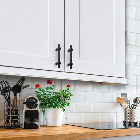 Matte Black 25 Pack Cabinet Handles 3 Inch Hole Centers installed on white kitchen cabinet doors, showcasing modern design.