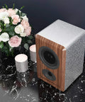 Speaker on table with candles and flowers, partially covered with Easy Peel And Stick Glitter Wallpaper For Walls And Surfaces.
