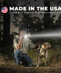 Man using Compact Powerhouse Mini LED Flashlight With 2Cell AA Batteries High Brightness Beam in forest with dog at night
