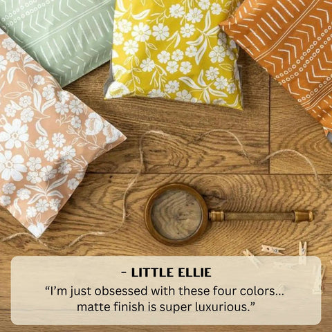 Assorted colored patterned envelopes on wooden surface with magnifying glass