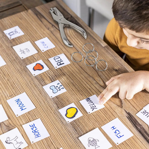 Kid using Super Handy Single Hole Punch For Crafts And Scrapbooks, Quarter Inch Hole, Punches Up To 8 Sheets, Includes 10 Binder Rings, Silver.