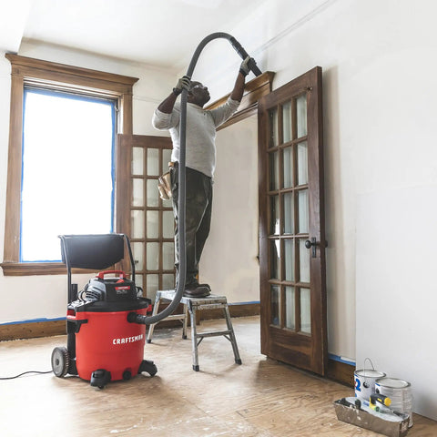 Person using All Purpose Wet Dry Vac Attachment Kit For Home And Shop Use, Industrial Grade Vacuum Accessories with ladder and hose.