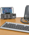Under Desk Workhorse Three Outlet Surge Protector Power Strip With Desk Clamp And USB Charging Ports Ten Foot Cord 510 Joules Black on desk with phone and keyboard