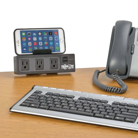Under Desk Workhorse Three Outlet Surge Protector Power Strip With Desk Clamp And USB Charging Ports Ten Foot Cord 510 Joules Black on desk with phone and keyboard