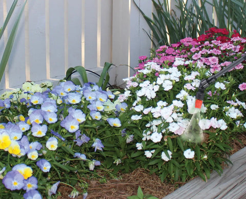 2 Gallon Handheld Sprayer With Base Large Four And A Half Inch Fill Opening 20 Inch Unbreakable Wand spraying colorful garden flowers
