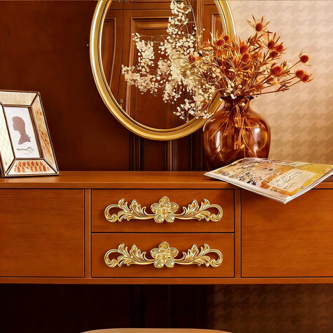 Upgrade Your Furniture Game Now With These Hella Charming Golden Floral Cabinet Handles And Vintage Drawer Pulls Designed To Bring Major Retro Swagger To Dresser Drawers And Bedroom Wardrobe Cabinetry Projects Instantly on a wooden dresser.