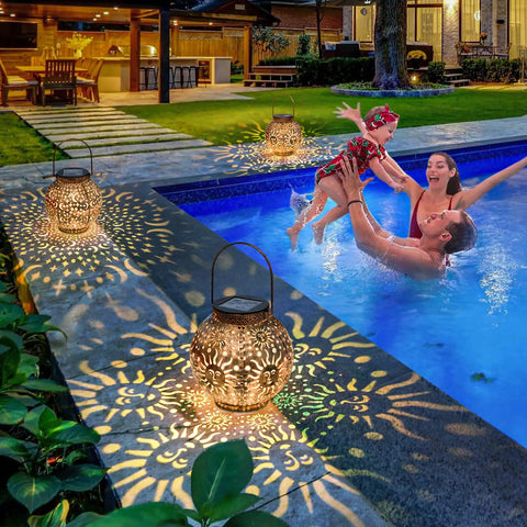 Two Pack Solar Lanterns Outdoor Waterproof Bronze Moon Star Sun Design Lights casting patterns by poolside, creating cozy vibes