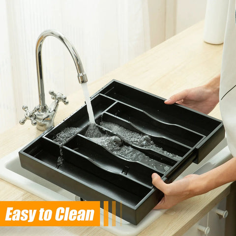 Expandable Bamboo Silverware Organizer being cleaned under a faucet, showing adjustable compartments, fits kitchen drawers.