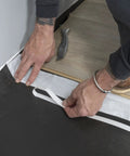 Hands installing Straight Shooter Floor Underlayment For Laminate And Engineered Wood, 600 Square Foot Roll in a room.
