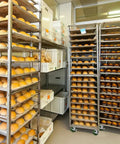 Commercial bakery racks loaded with bread on Beefy 4 Inch By 1.5 Inch Heavy Duty Oven Rack Casters Set Of 4 With 2800 Lbs Capacity